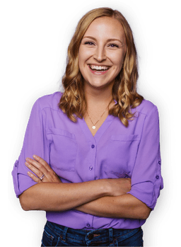 WP Engine team member wearing a purple shirt smiling with crossed arms