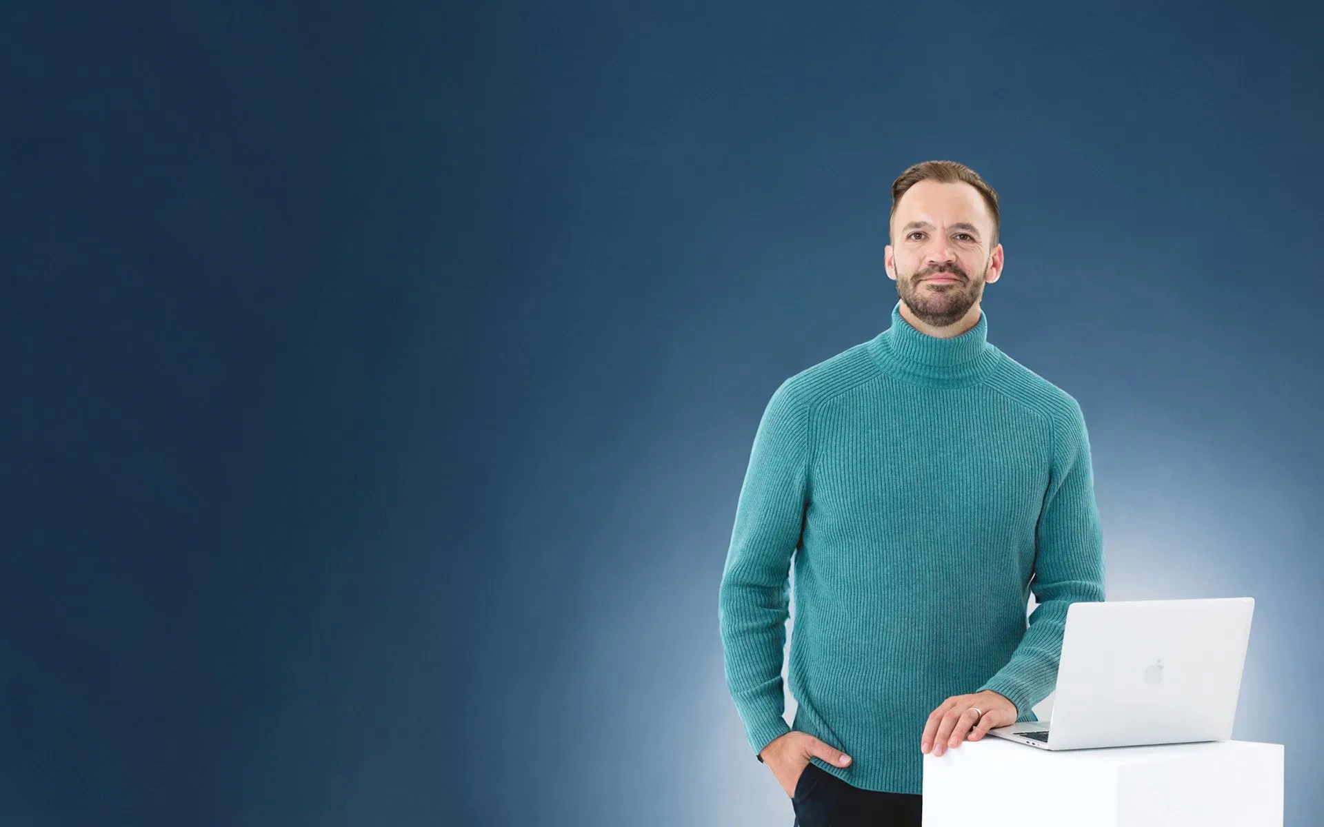 Calm user in turtleneck standing with laptop.