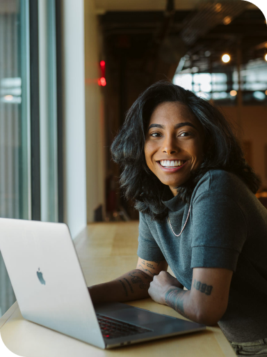 person smiling at laptop working on WP Engine Headless WordPress team