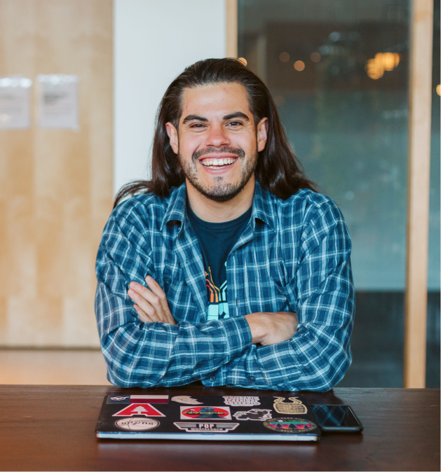 Man with closed laptop and crossed arms smiling