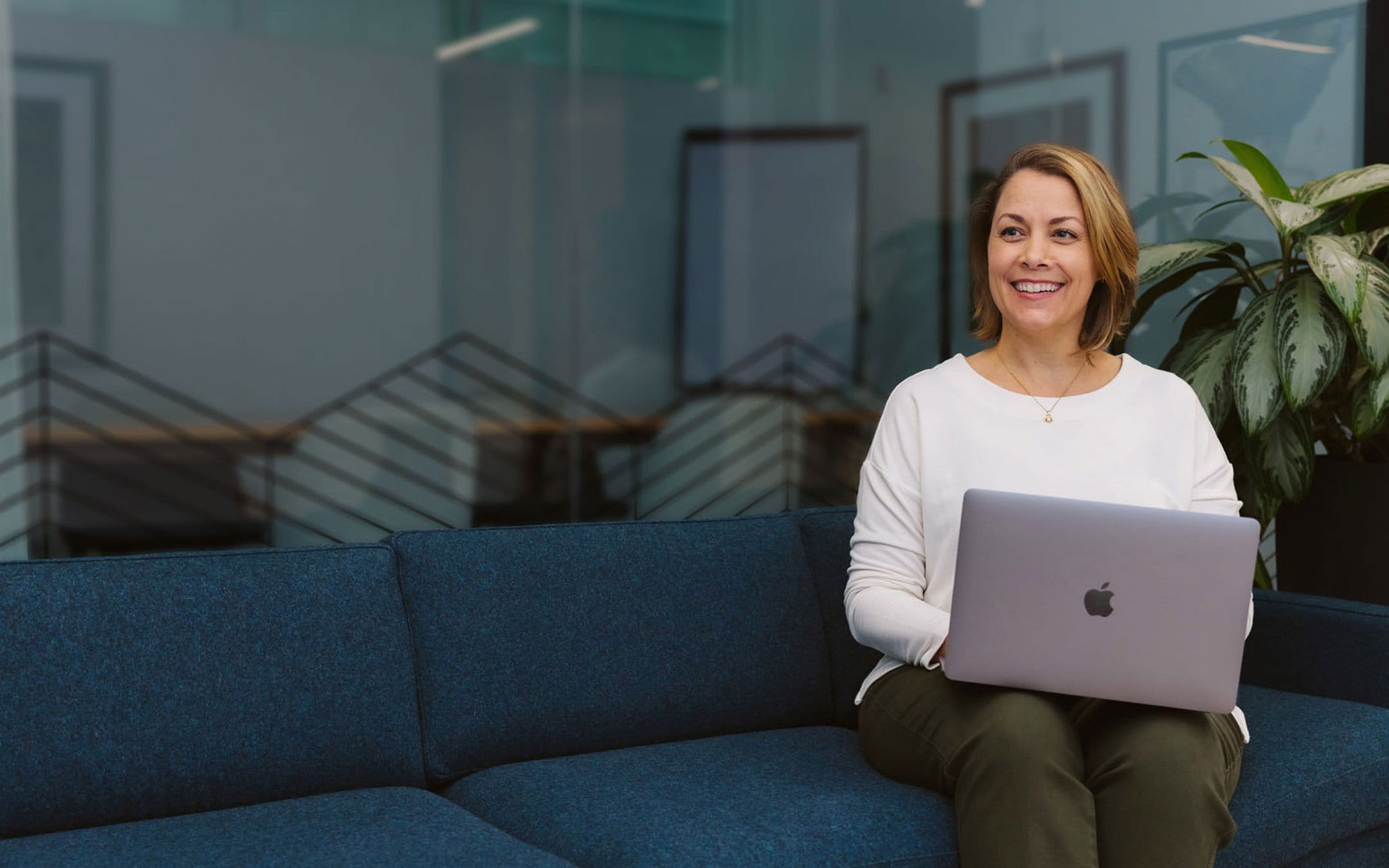 Woman looking happy with laptop in ecommerce workspace