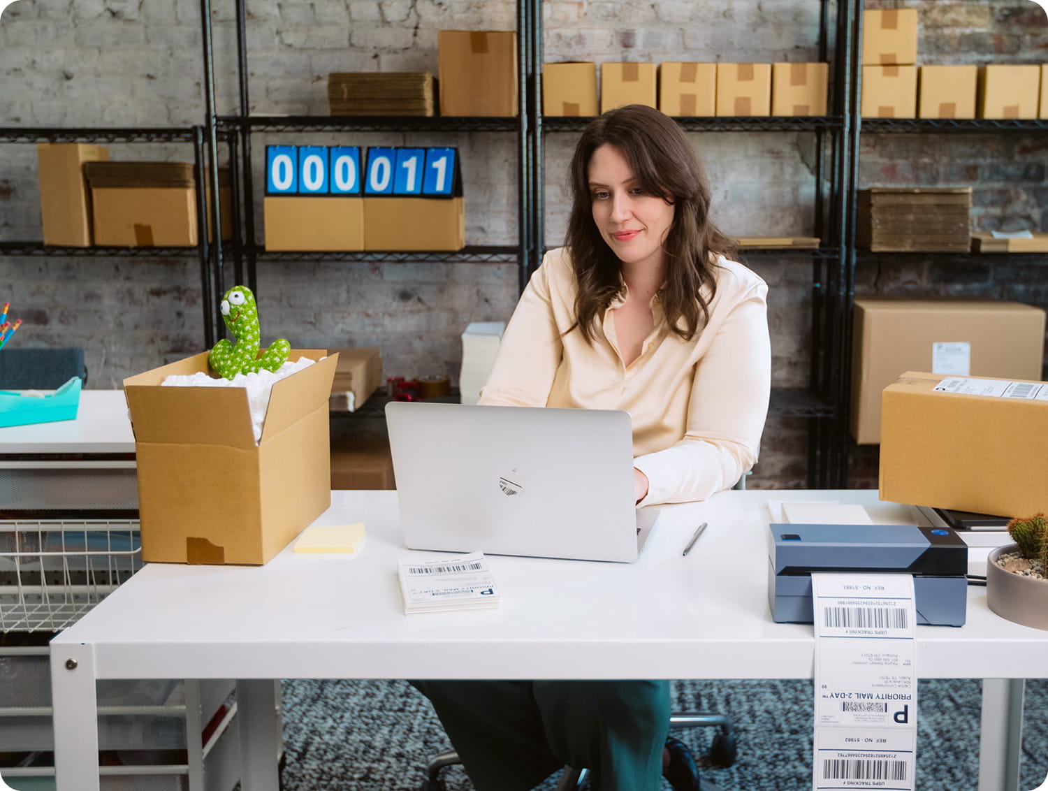 Calm customer using a laptop on a table surrounded by inventory.