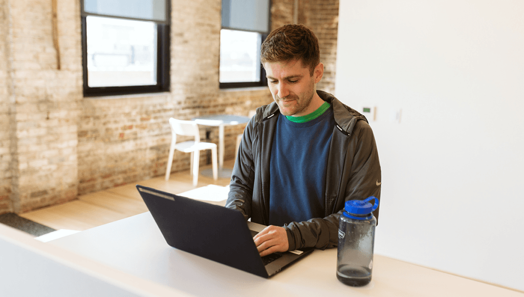 Man looking at his laptop hopefully