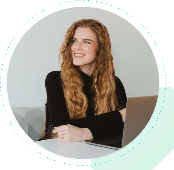 Woman sitting at a desk with closed laptop looking to the side