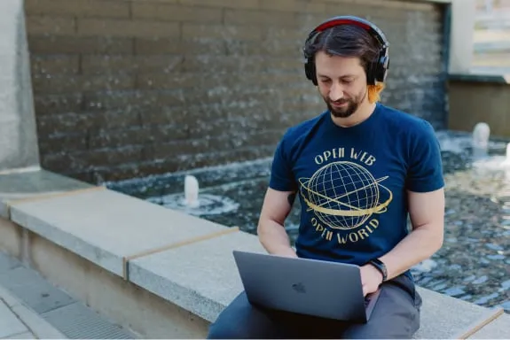 Man with headphones looking at laptop screen