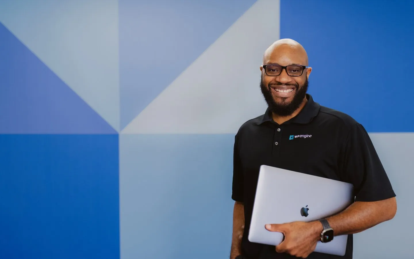 WP Engine employee smiling with laptop in hand