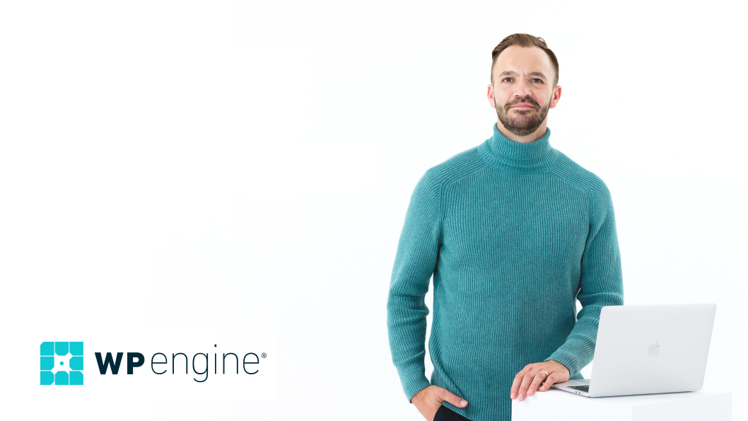 WP Engine Representative in teal turtleneck standing behind a laptop on a stand with white background