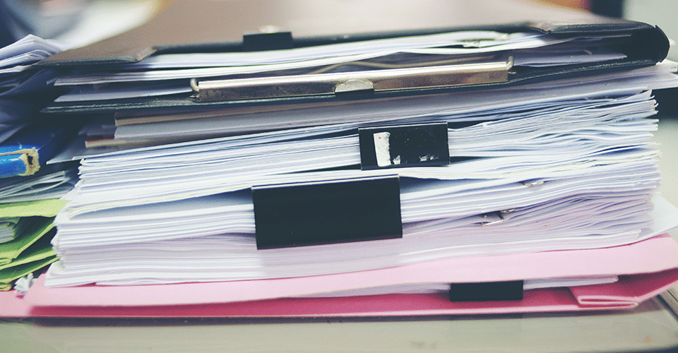 a stack of contracts on a desk