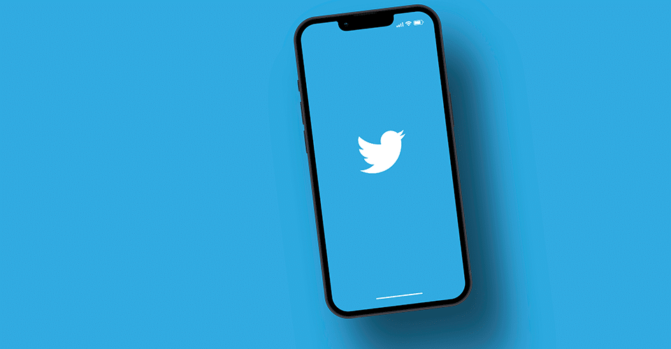 Twitter app on a smartphone laying on a light blue background