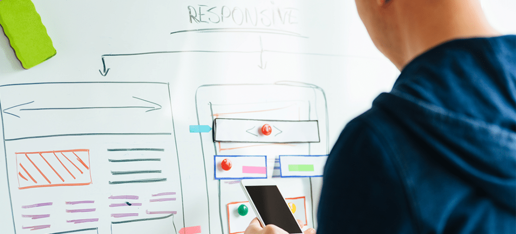 a man plans a responsive web design using a white board