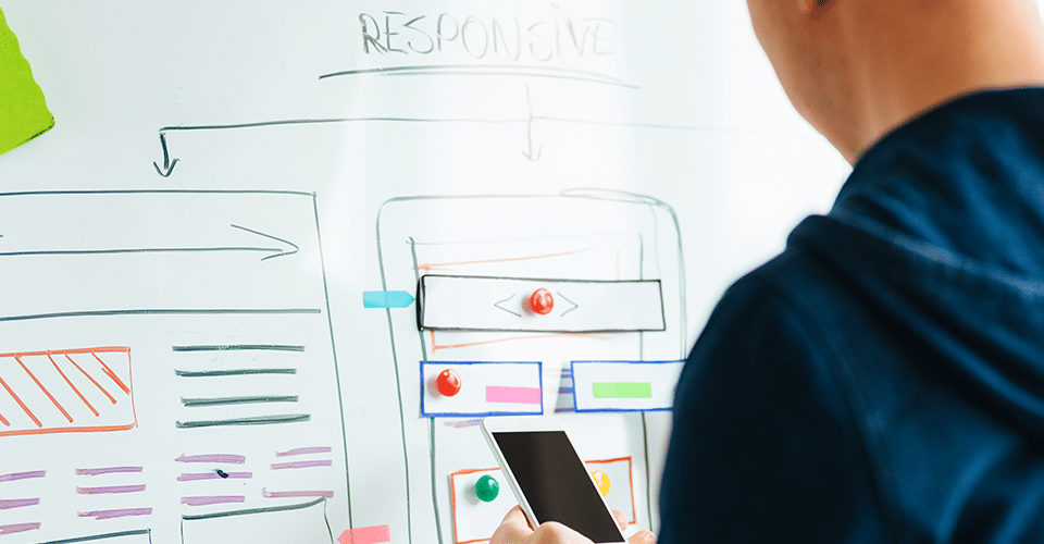 a man plans a responsive web design using a white board