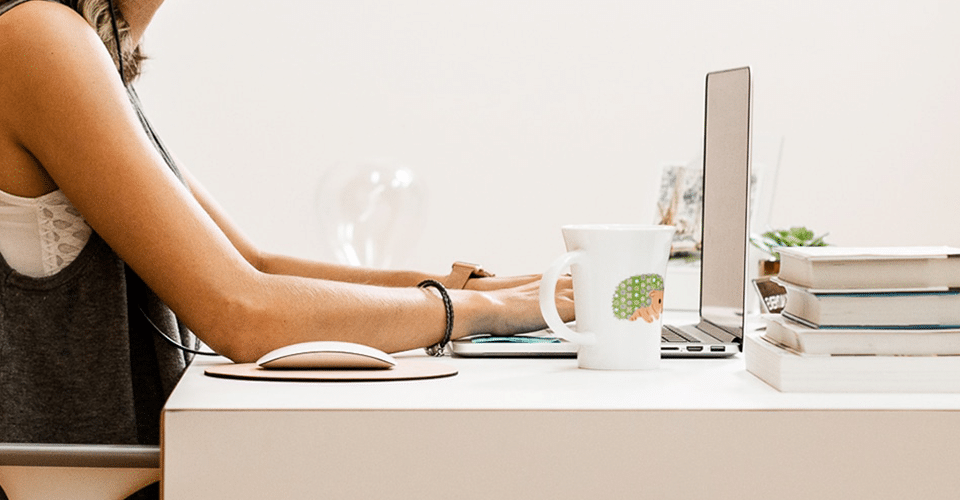 An expert in web design and digital marketing+2 diligently working on a laptop at a desk.