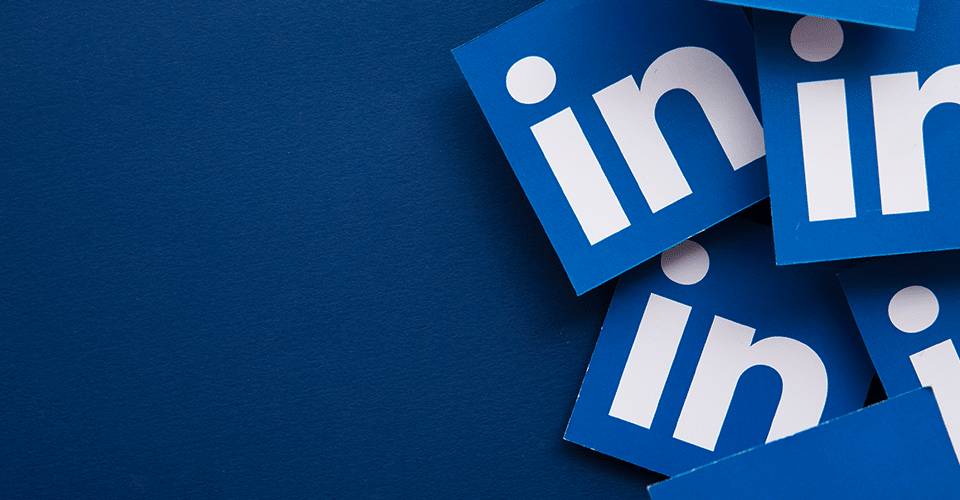 multiple pages printed with the "in" logo aspect of LinkedIn on a blue background