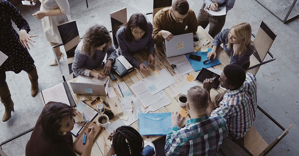 WordPress Plugins for HR & Employee Management. a team collaborates on a project at a large conference table