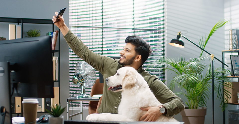 a man created user generated content at his desk with a dog