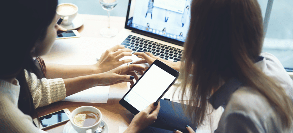 designer showing client new website on desktop and mobile device