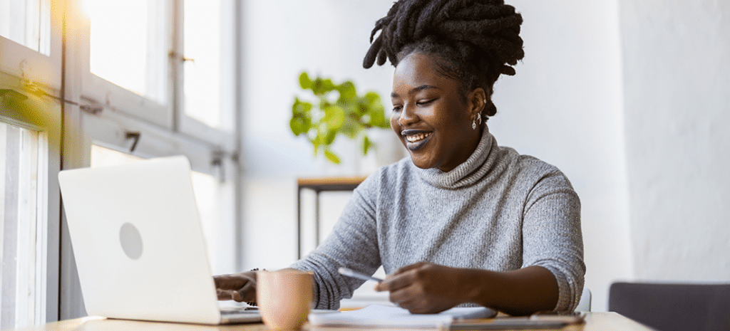 A woman starts an online course in a brightly lit coffee shop