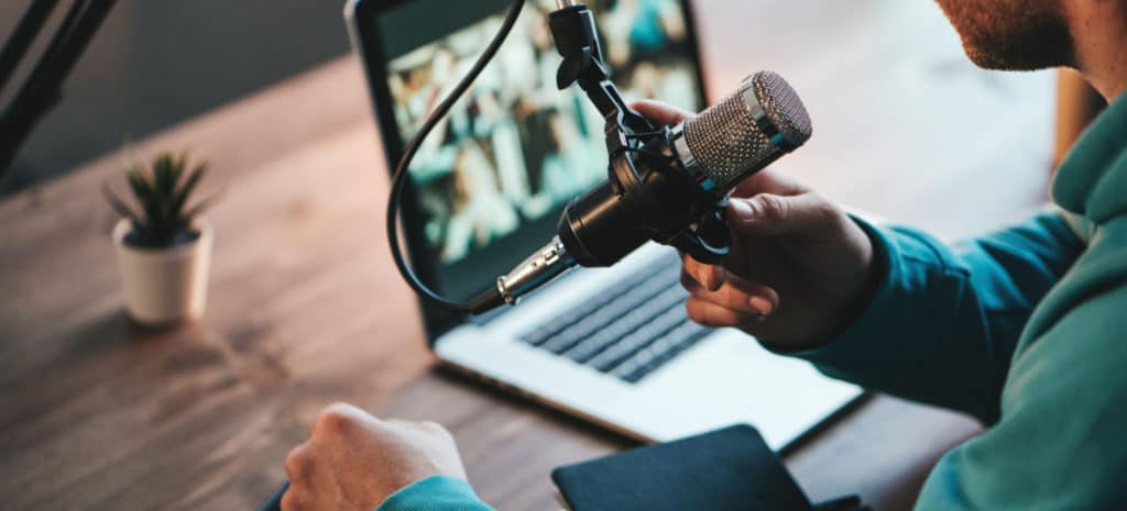 Podcast microphone in front of a laptop screen