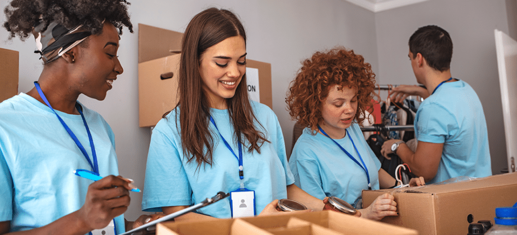 four volunteers pack boxes while working for a nonprofit organization