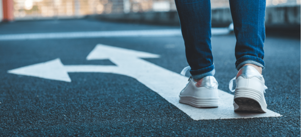 two white arrows on the street pointing different ways