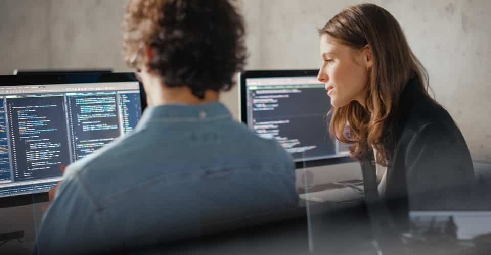 A man and woman looking at code. How To Change Font In Wordpress
