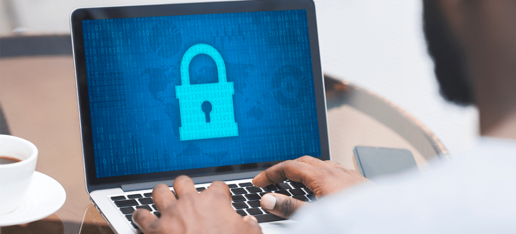 a person working on cybersecurity using a laptop which displays a large padlock icon