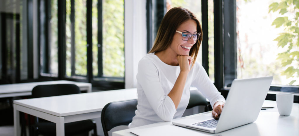 smiling woman looking at a WordPress wiki on her laptop