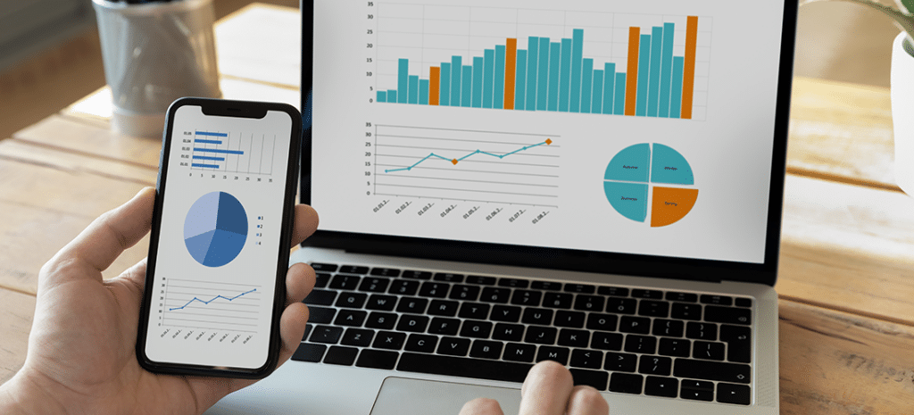 a person reviews a series of charts on both a laptop and mobile device