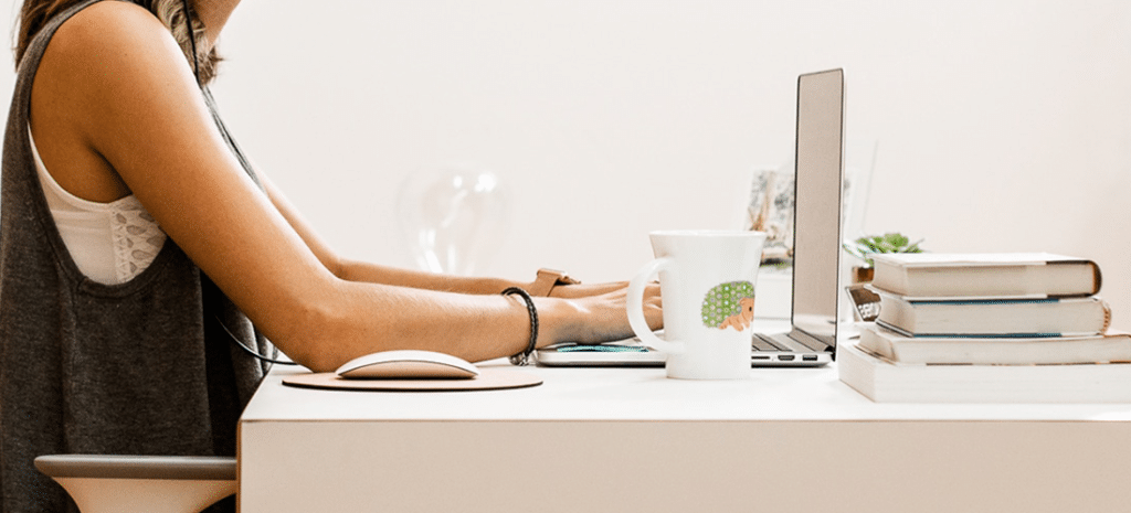 An expert in web design and digital marketing+2 diligently working on a laptop at a desk.