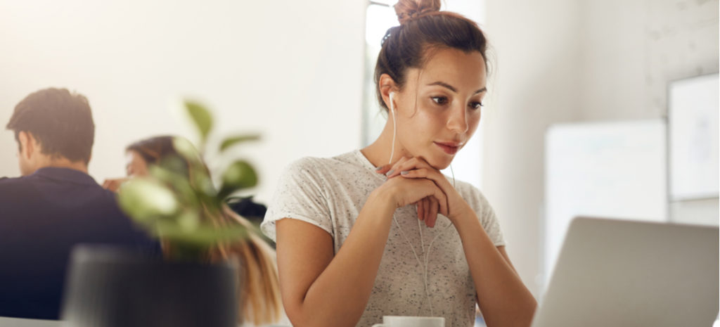 Photo of woman in bright coworking space working to fix HTML on laptop. how to fix wordpress formatting and alignment issues