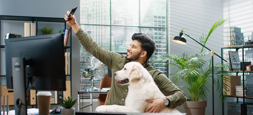 a man created user generated content at his desk with a dog