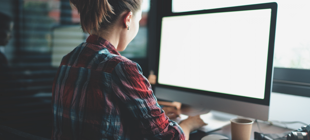 woman utilizing managed WordPress hosting features on desktop computer in office environment