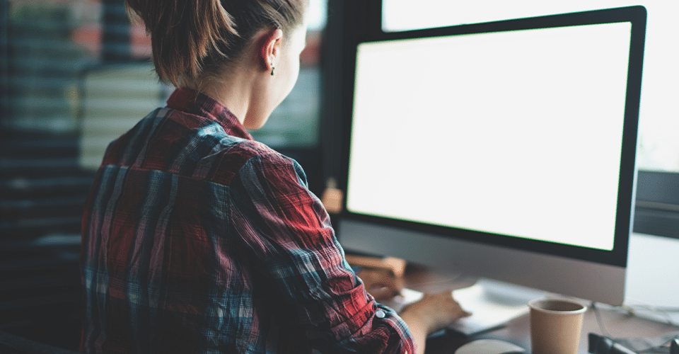 woman utilizing managed WordPress hosting features on desktop computer in office environment