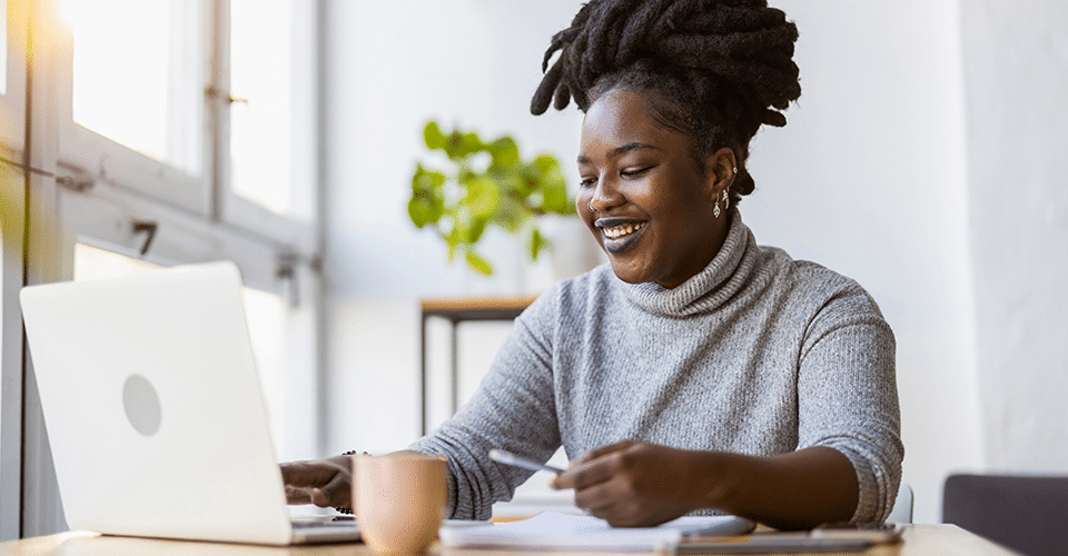 A woman starts an online course in a brightly lit coffee shop