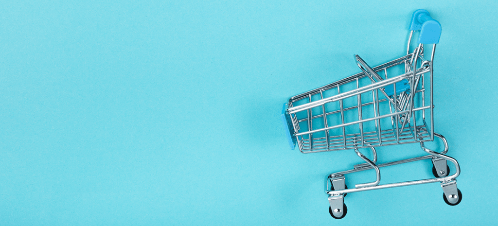 Integrate BigCommerce plugin with WordPress. Image depicts a miniature shopping cart on a light blue background