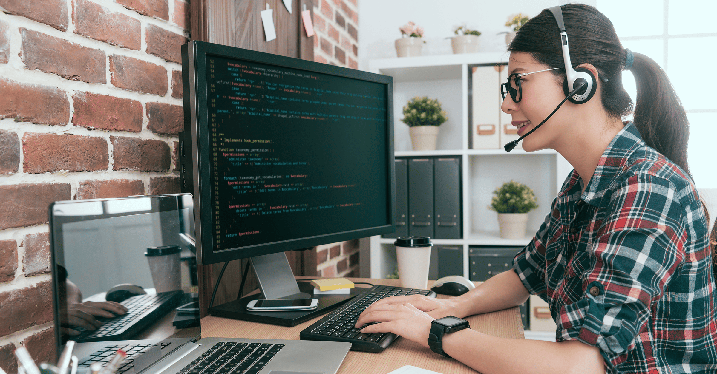 woman wearing headphones while working on code for a client site