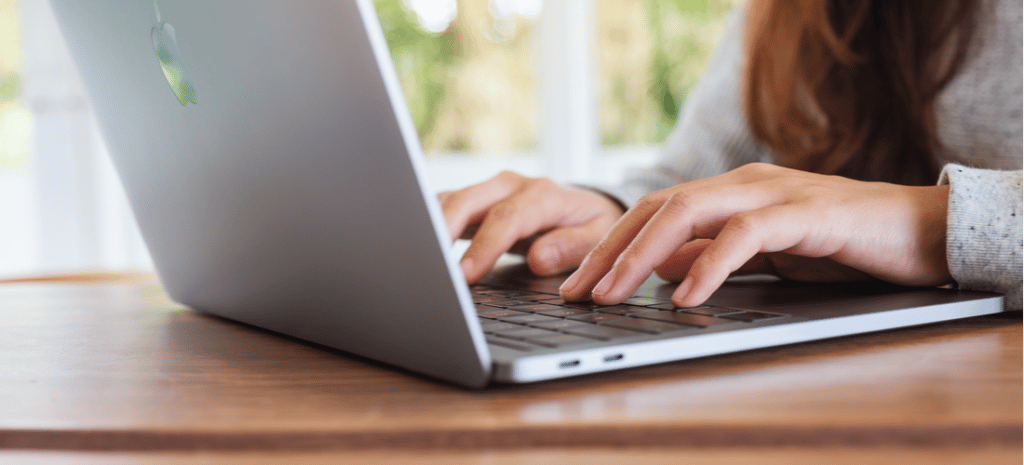 A woman using and typing on Apple MacBook Pro laptop computer