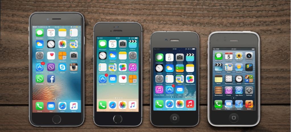 Front view of a space grey color iPhones 6, 5s, 4 and 3gs generation showing the home screens on wooden background