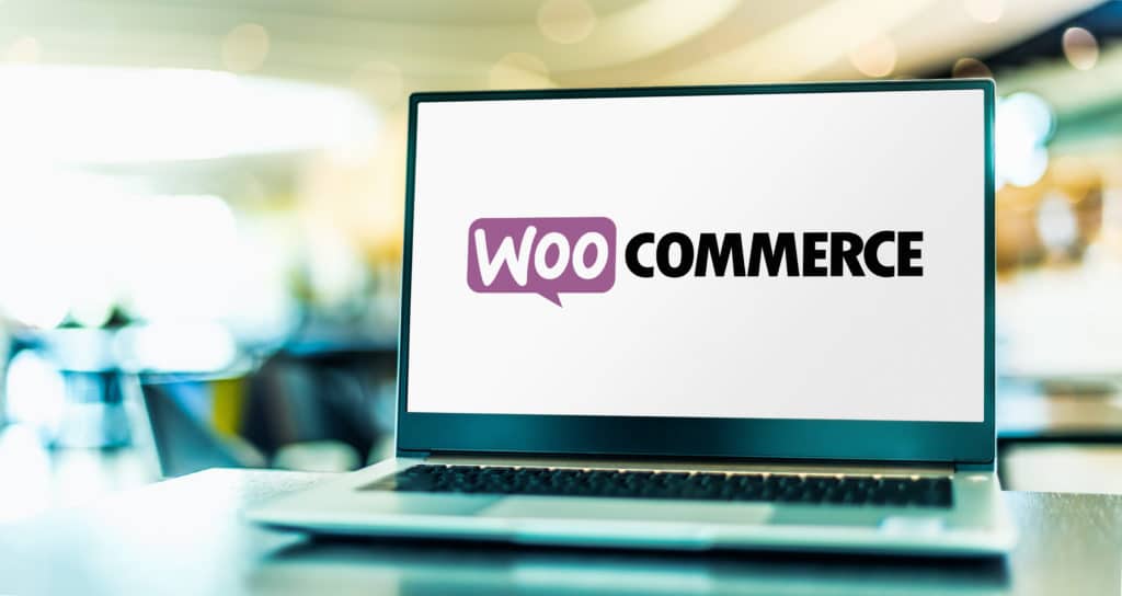 A laptop screen displays the WooCommerce logo