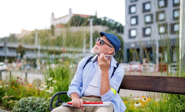 Visually impaired man listens to his phone